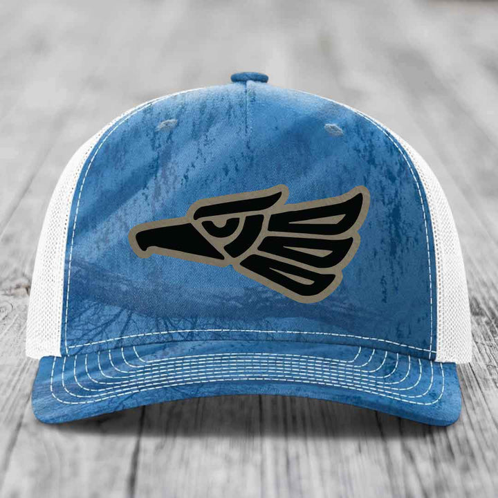 Blue and white trucker hat with an Aztec-style eagle patch on the front.