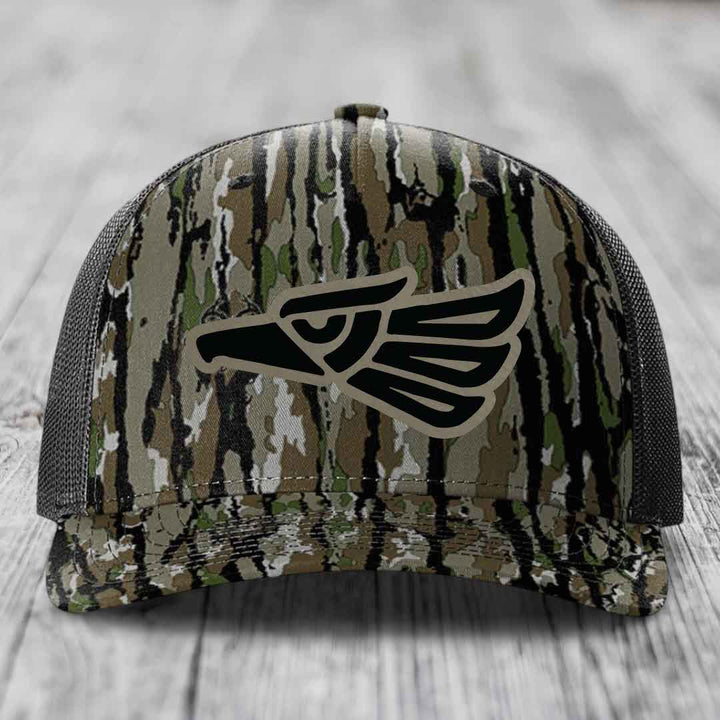 Camouflage trucker hat with black eagle patch on front, gray mesh back.