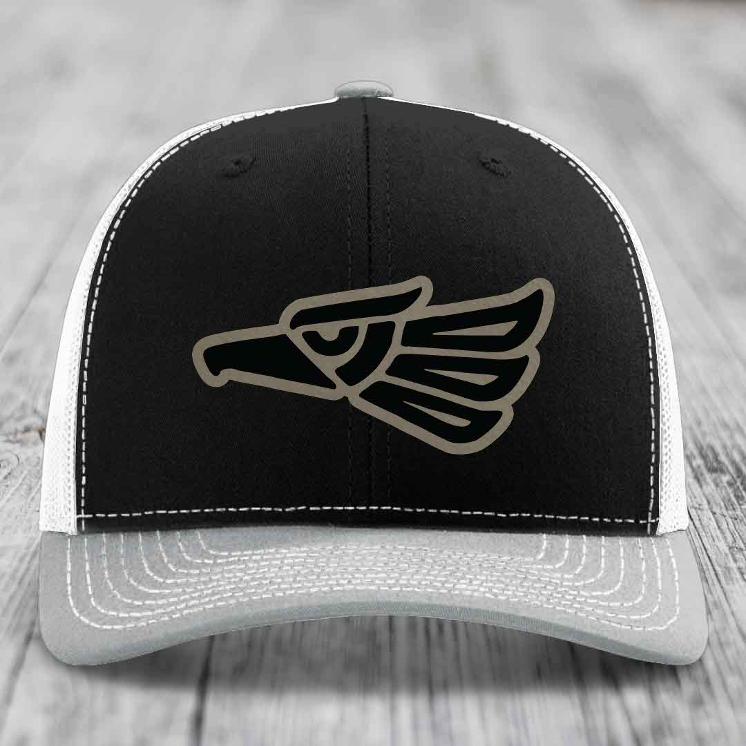 Black and white trucker hat with embroidered eagle patch on front.