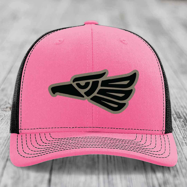 Pink trucker hat with black and grey Aztec eagle patch on front.