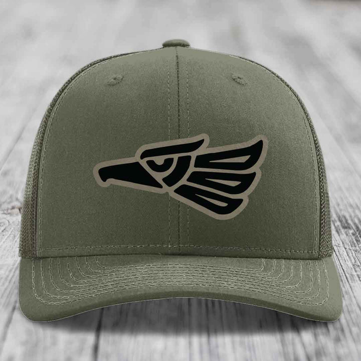 Olive green trucker hat with black and tan Aztec eagle patch on front.