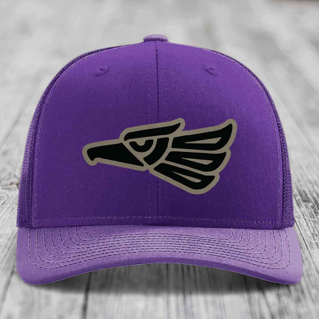 Purple trucker hat with black and tan Aztec eagle patch on front.