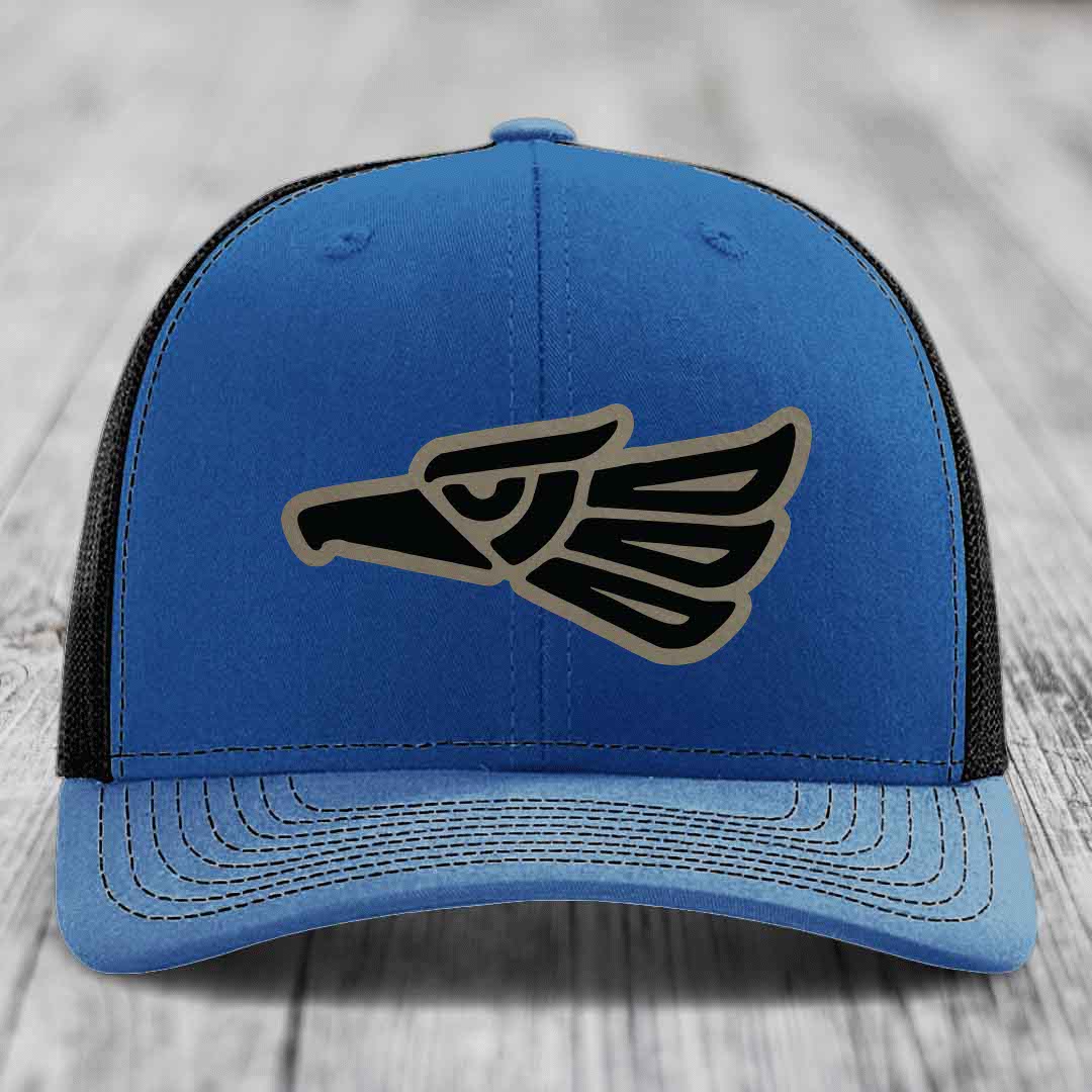 Blue trucker hat with black and tan eagle patch on front, black mesh back.