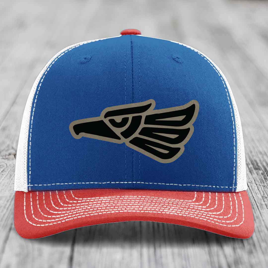 Blue and red trucker hat with black and grey Aztec eagle patch on front.