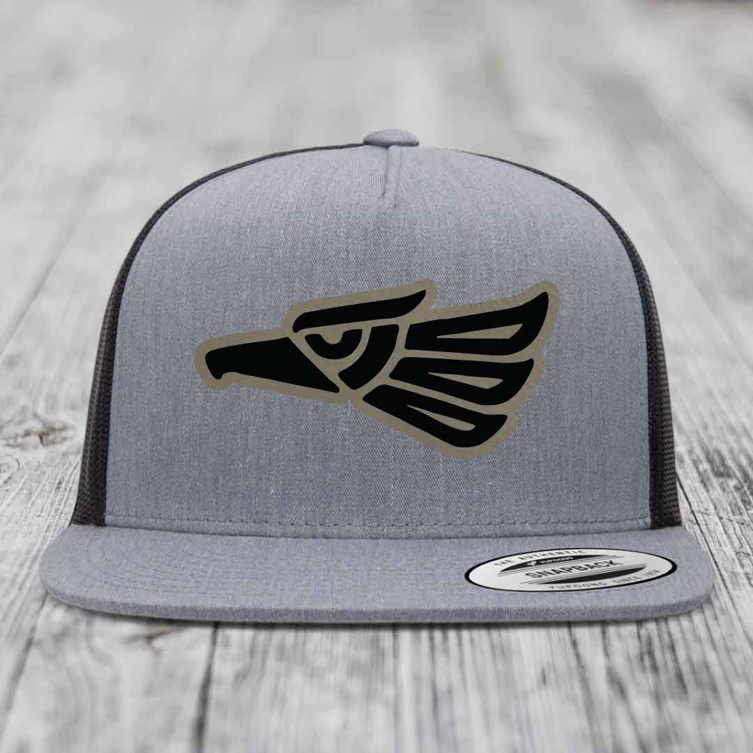 Grey trucker hat with black and tan Aztec eagle patch on front.