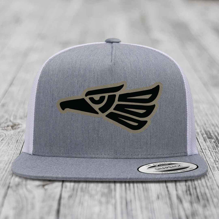 Grey trucker hat with black and tan Aztec eagle patch on front, white mesh back.