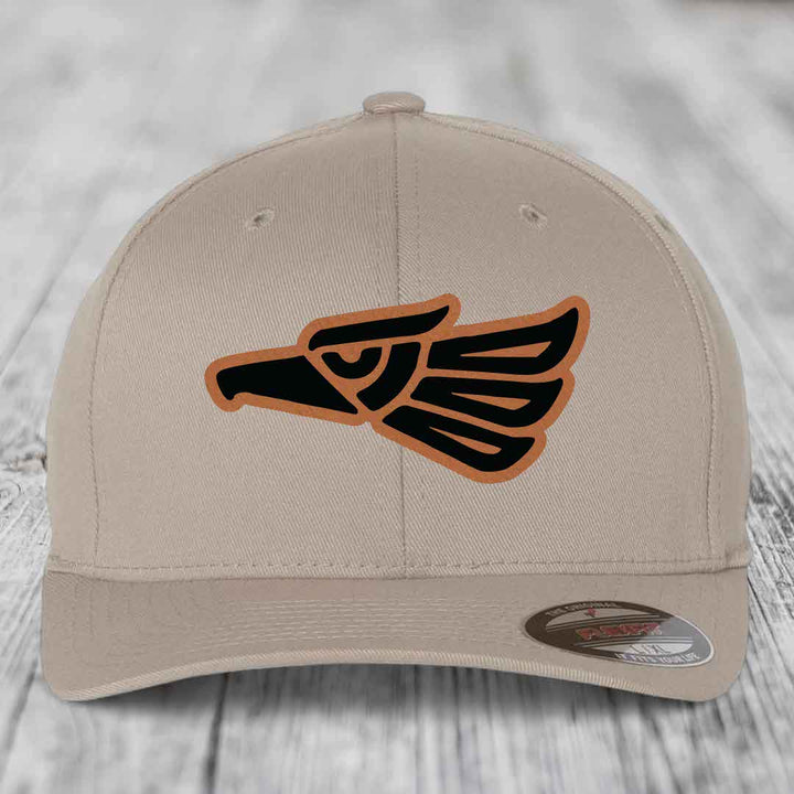 Beige baseball cap with black and tan Aztec eagle leather patch on front.
