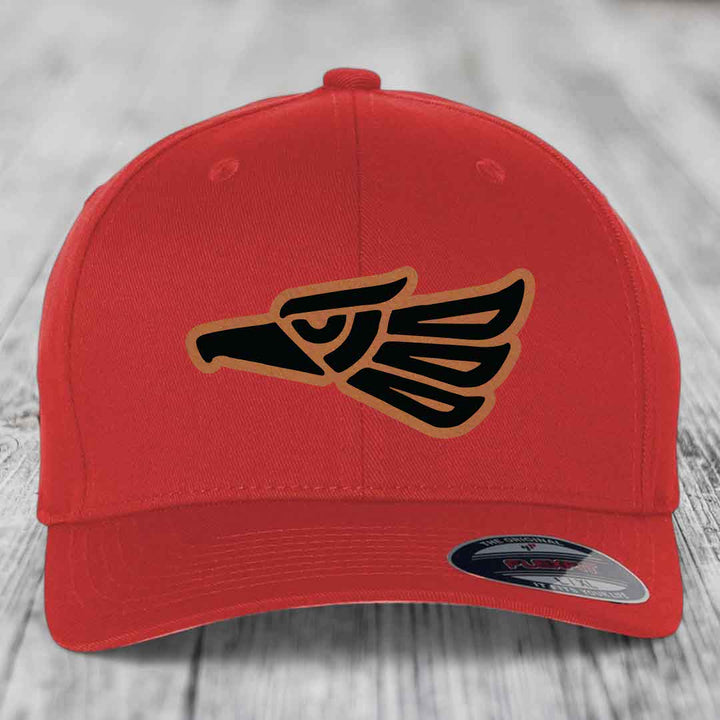 Red baseball cap with Aztec-style eagle patch on front, featuring black and tan design.