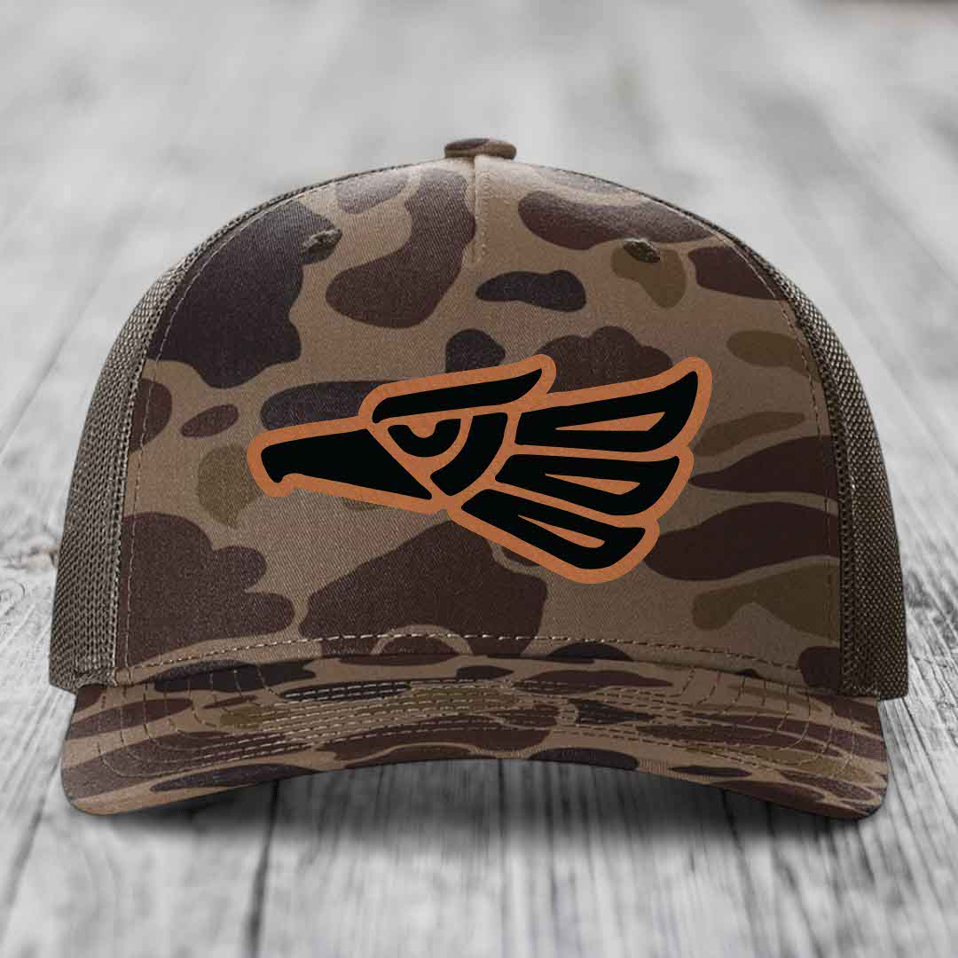 Camouflage trucker hat with Aztec eagle patch in black and tan.