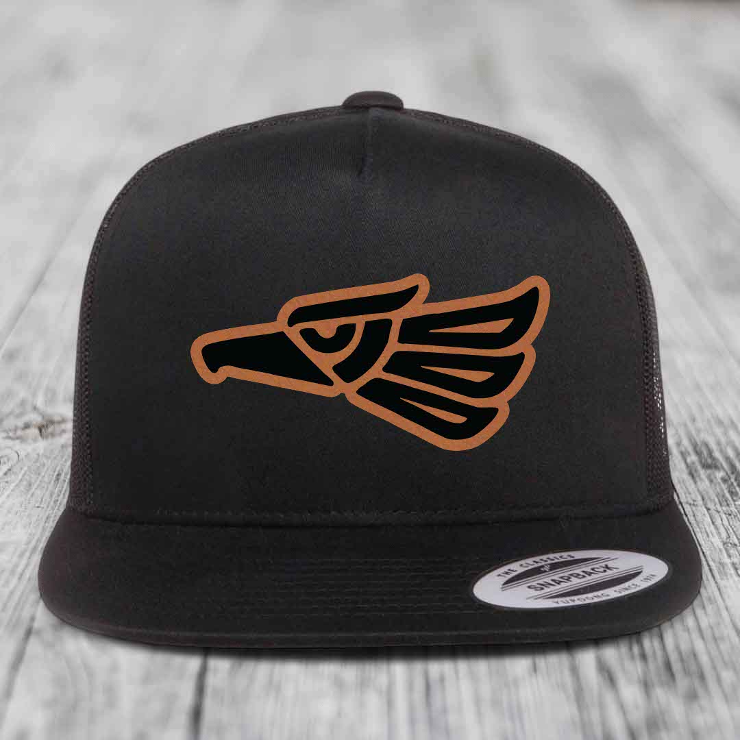 Black snapback hat with brown and black Aztec eagle leather patch on front.