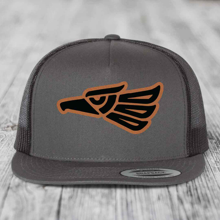 Grey trucker hat with black and tan Aztec eagle leather patch on front.