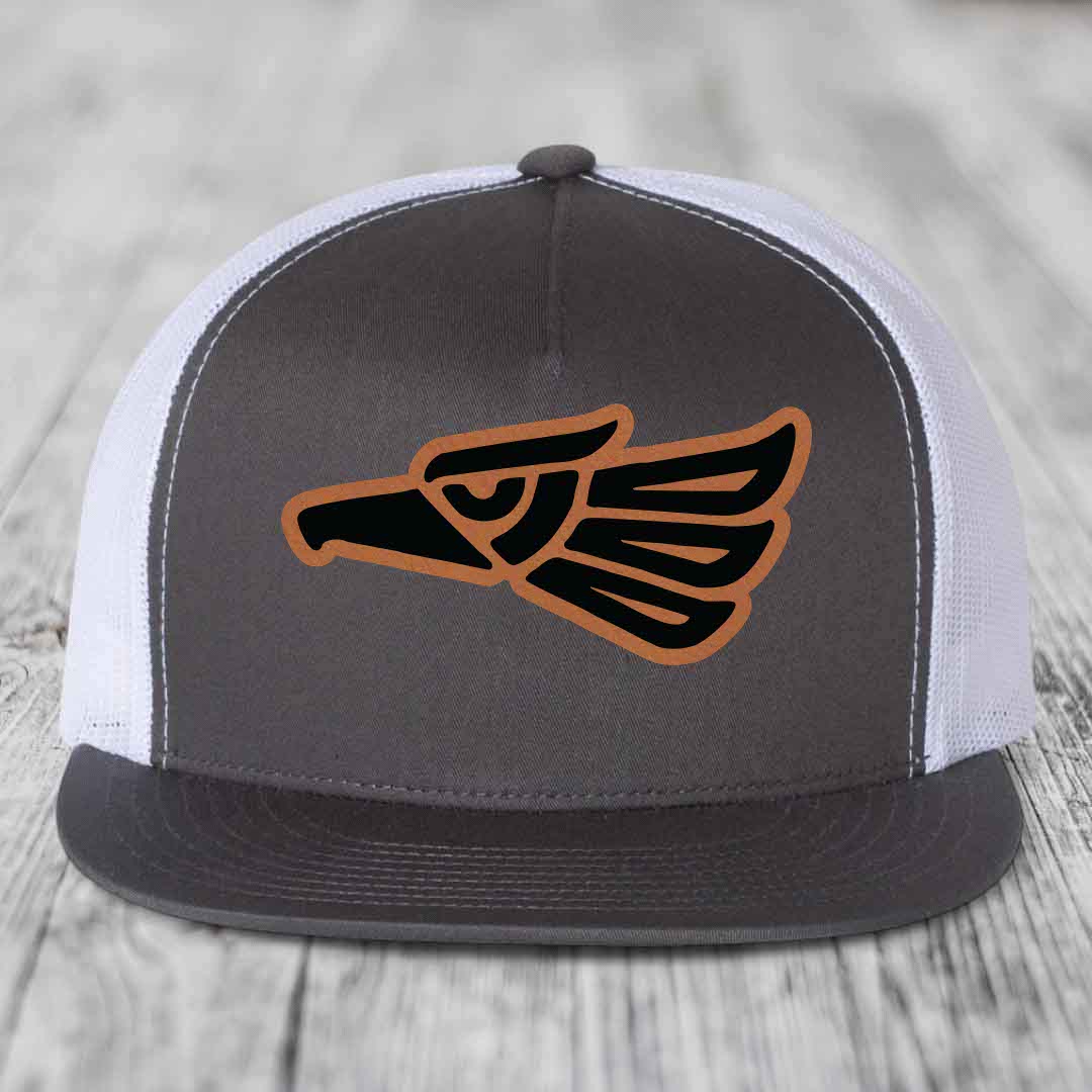 Grey front panel trucker hat with brown and black Aztec eagle patch.