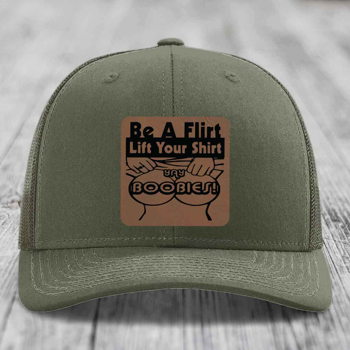 Olive green trucker hat with a brown leatherette patch that says &