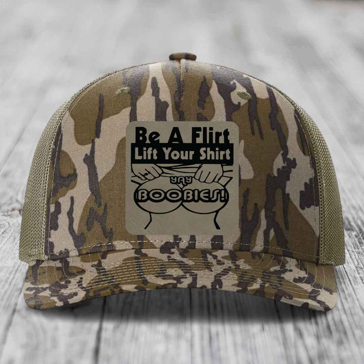 Camouflage trucker hat with black patch reading &