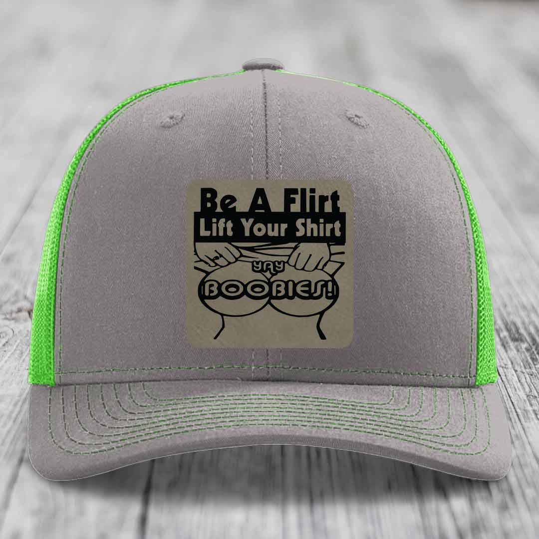 Grey trucker hat with neon green mesh and stitching, featuring a &