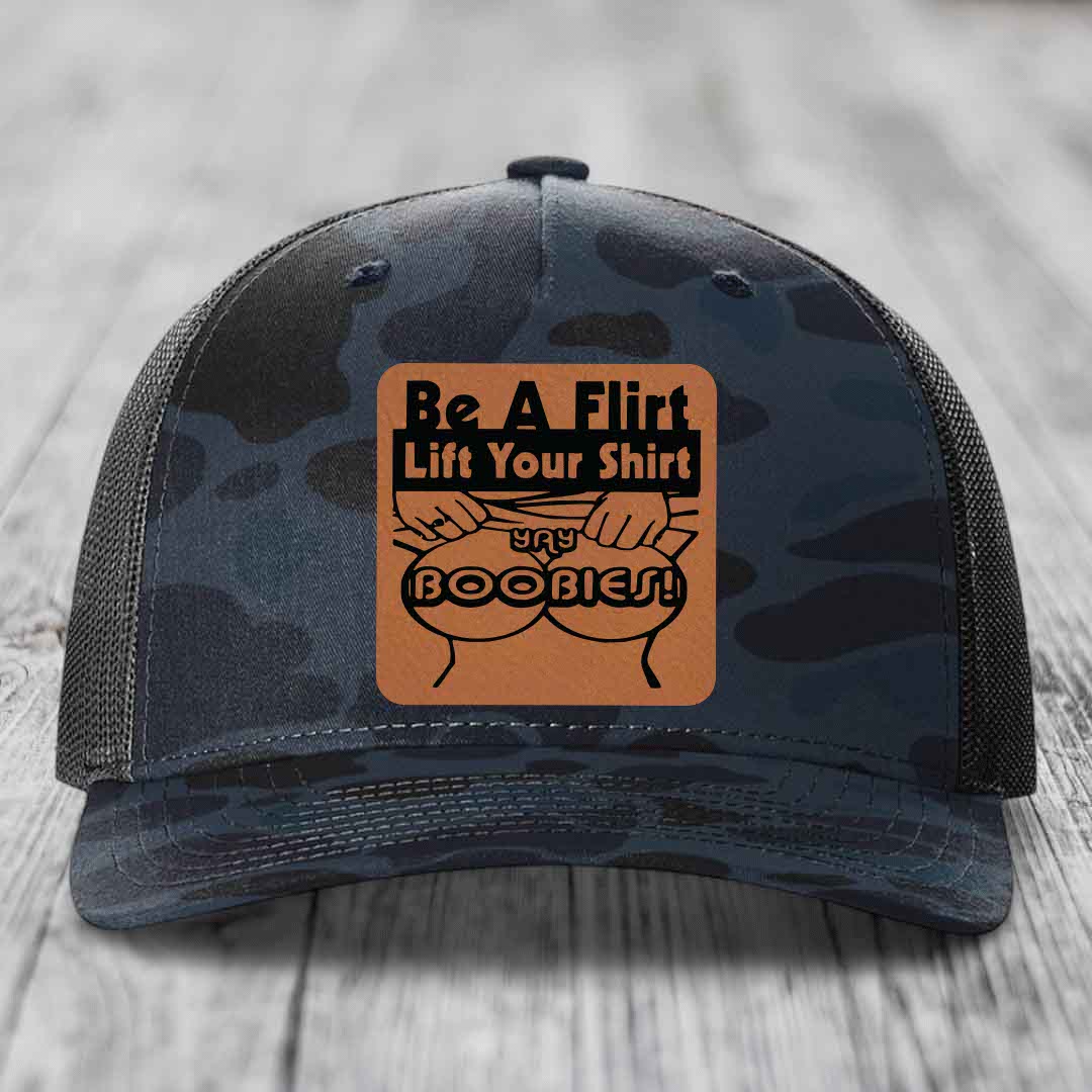 Camouflage trucker hat with brown leather patch reading &