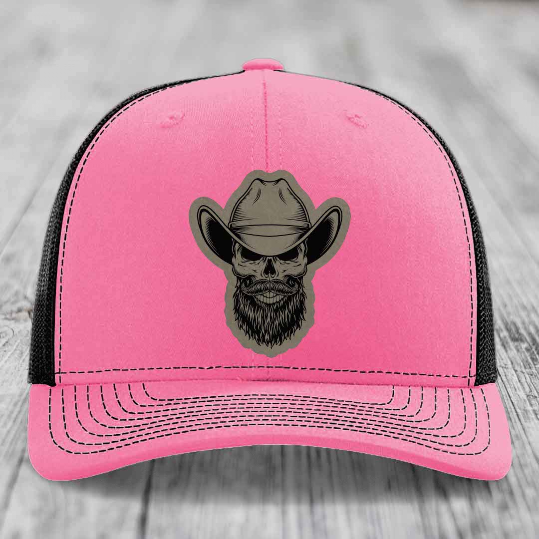 Pink trucker hat with black mesh back and a bearded cowboy skull patch on front.