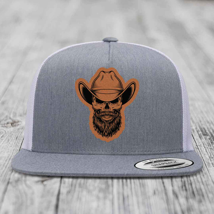 Grey trucker hat with brown leatherette patch of bearded cowboy skull wearing cowboy hat.