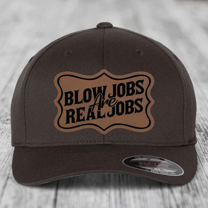 Dark brown baseball cap with a tan leatherette patch that reads &