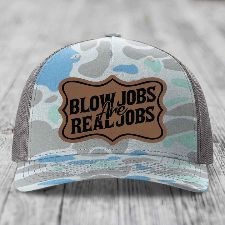 Camouflage trucker hat with brown leatherette patch reading &