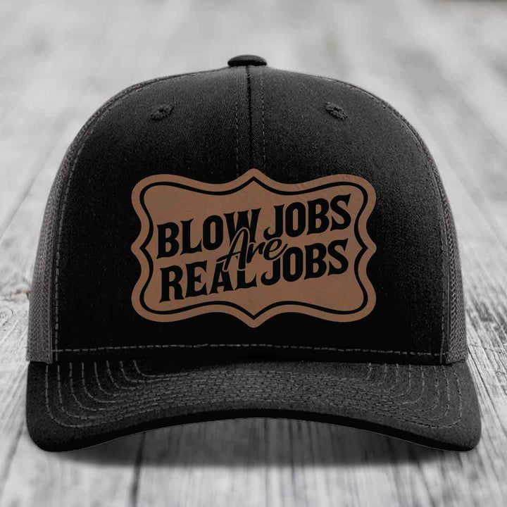 Black trucker hat with brown leatherette patch reading &