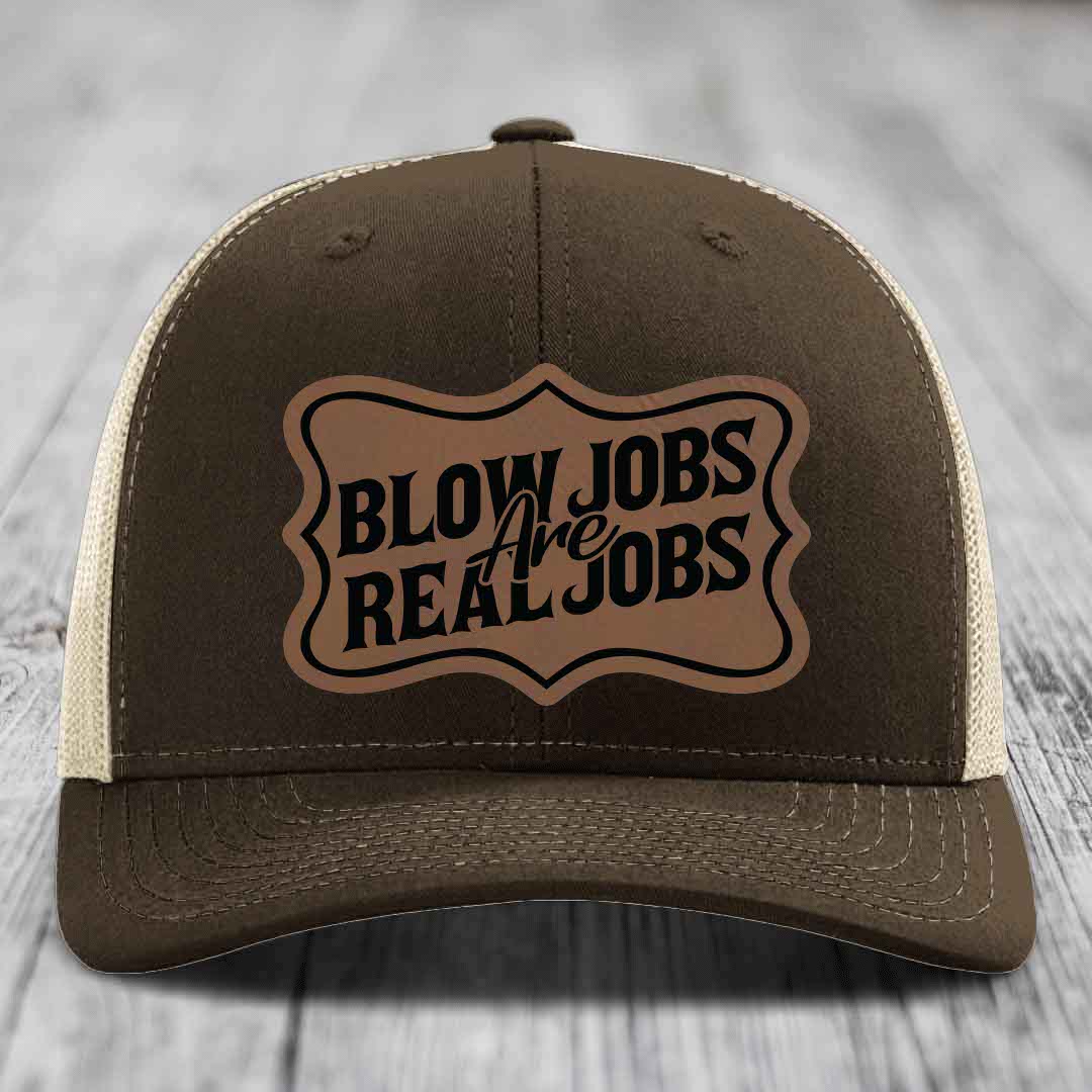 Brown trucker hat with beige mesh back and a brown leatherette patch that reads &