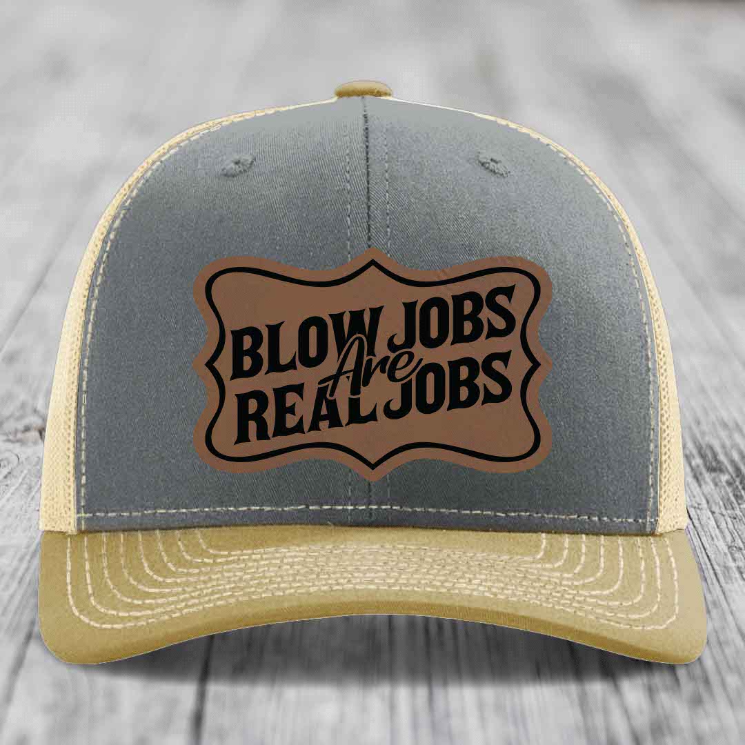 Grey and beige trucker hat with a brown leatherette patch that reads &