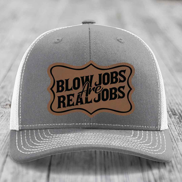 Grey trucker hat with brown leatherette patch reading &