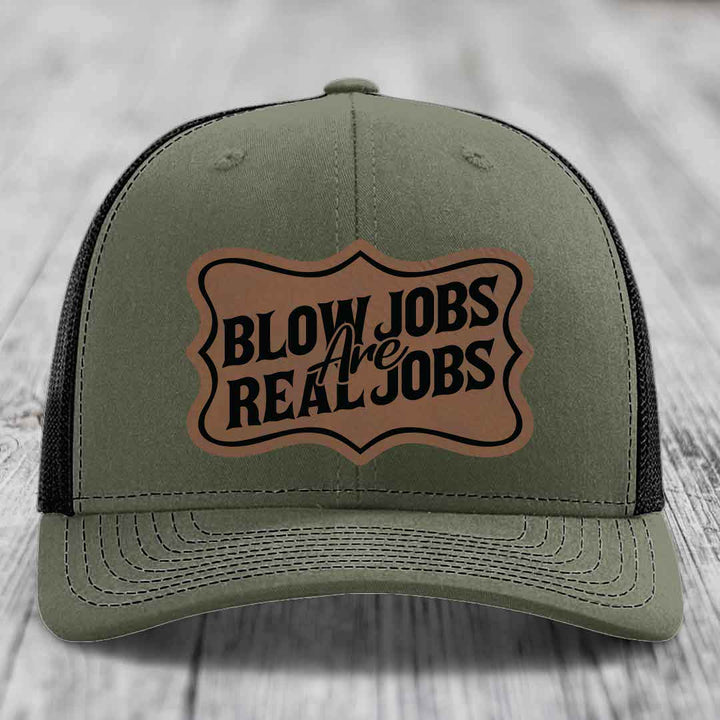 Olive green trucker hat with black mesh back and a tan leatherette patch that reads &
