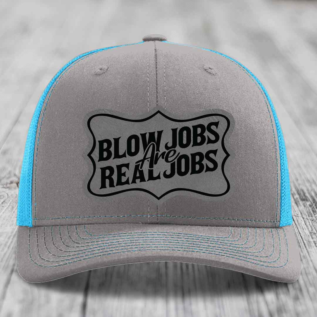 Grey trucker hat with blue mesh sides and black embroidered patch reading &