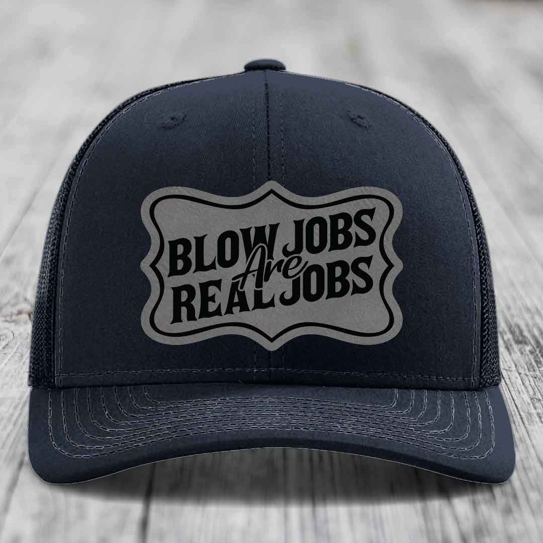 Black trucker hat with grey shield patch reading &