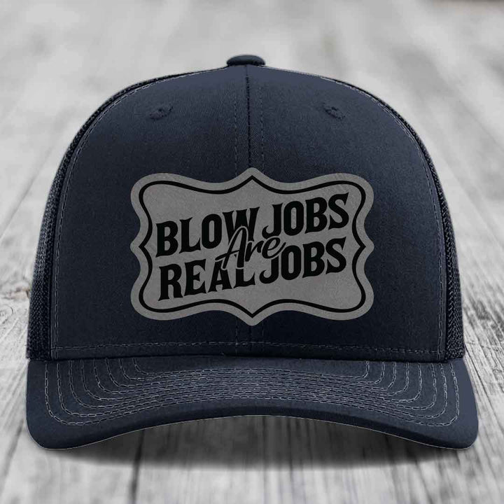 Black trucker hat with grey shield patch reading &