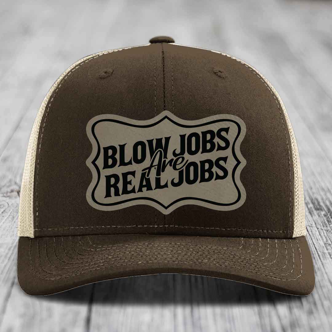 Brown trucker hat with beige mesh back and black embroidered patch reading &