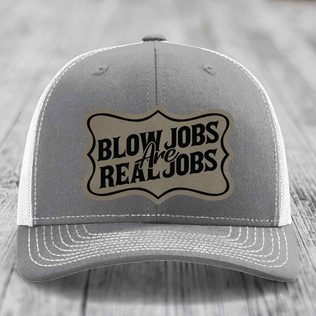 Grey trucker hat with white mesh back and embroidered patch reading &