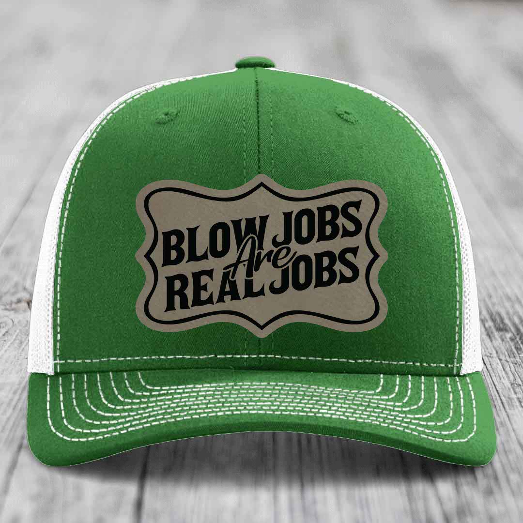 Green trucker hat with white mesh back and stitching, featuring a beige leatherette patch that reads &