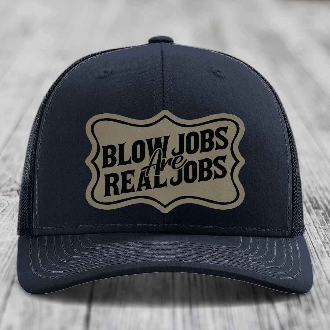 Dark blue trucker hat with beige leatherette patch reading &