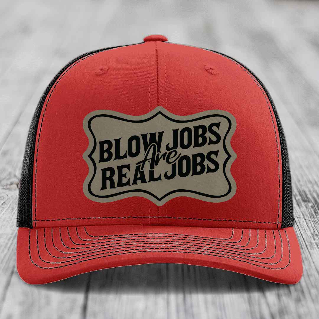 Red trucker hat with black mesh back and a beige leatherette patch that reads &