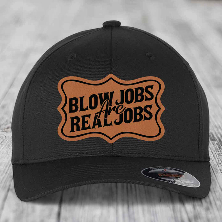Black baseball cap with brown leatherette patch reading &