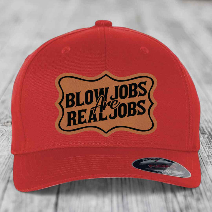 Red baseball cap with brown leatherette patch reading &