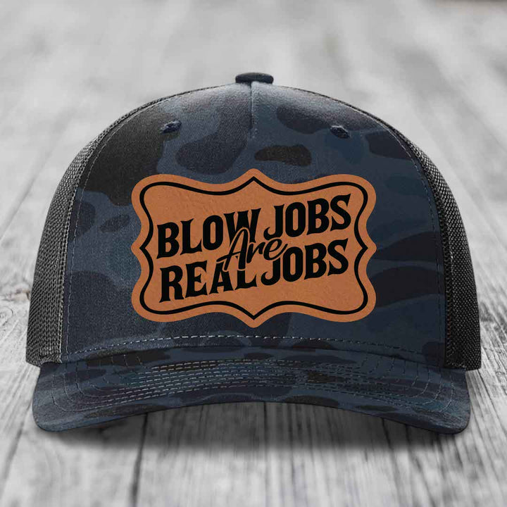 Camouflage trucker hat with brown leatherette patch reading &
