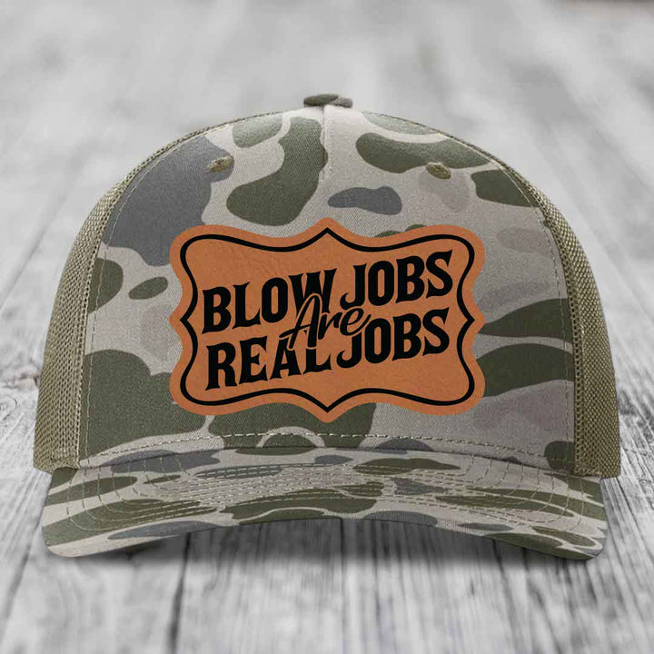 Camouflage trucker hat with brown leatherette patch reading &