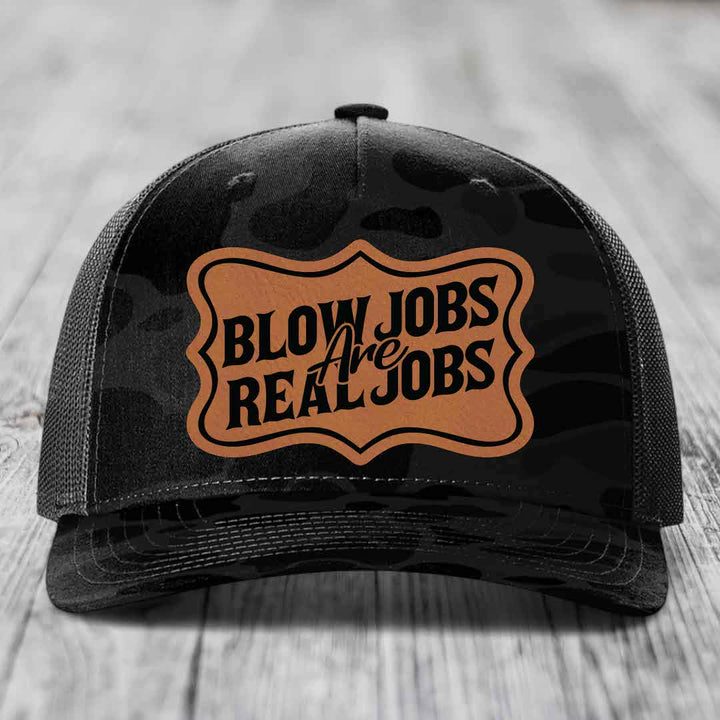 Black trucker hat with brown leatherette patch reading &