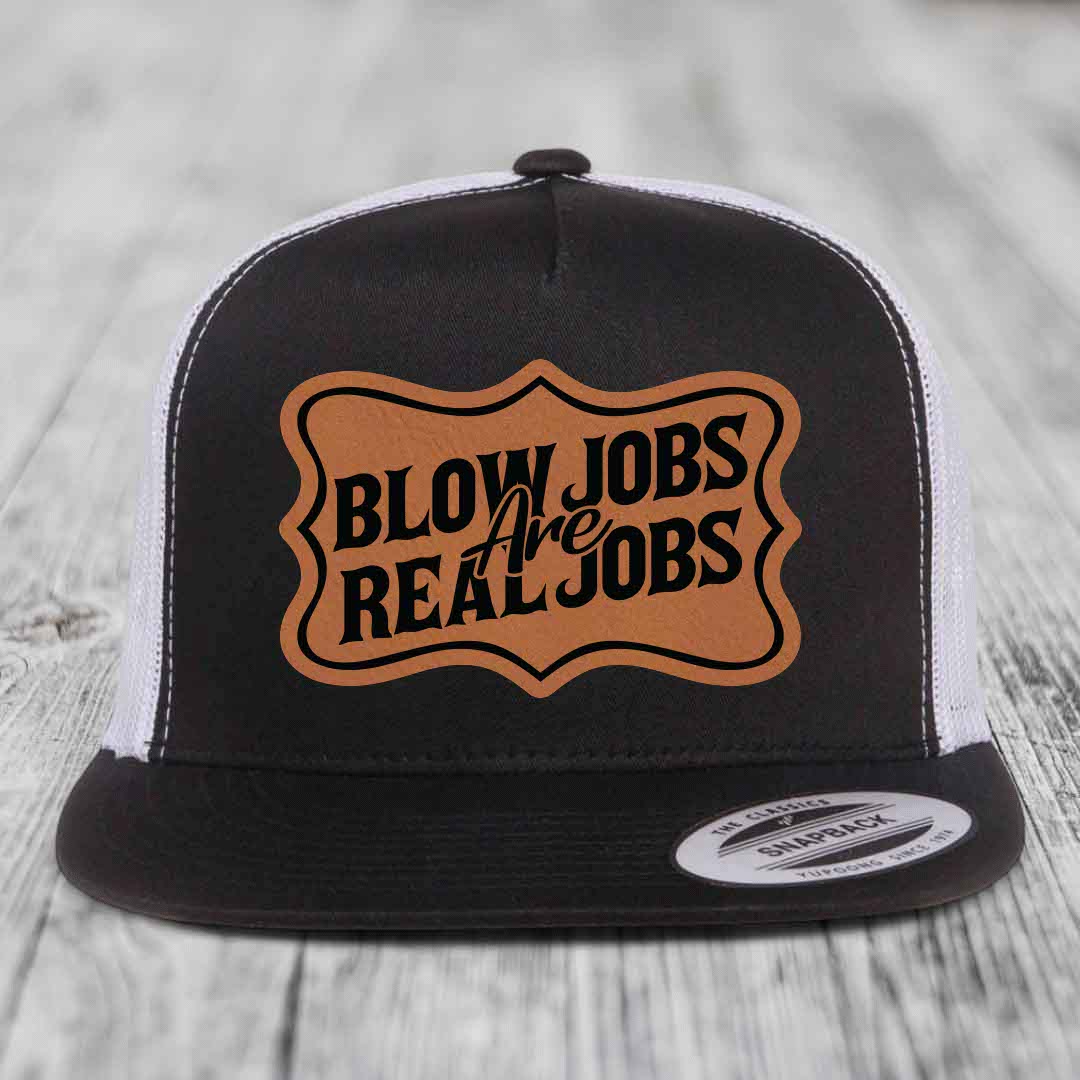 Black and white trucker hat with brown leather patch reading &