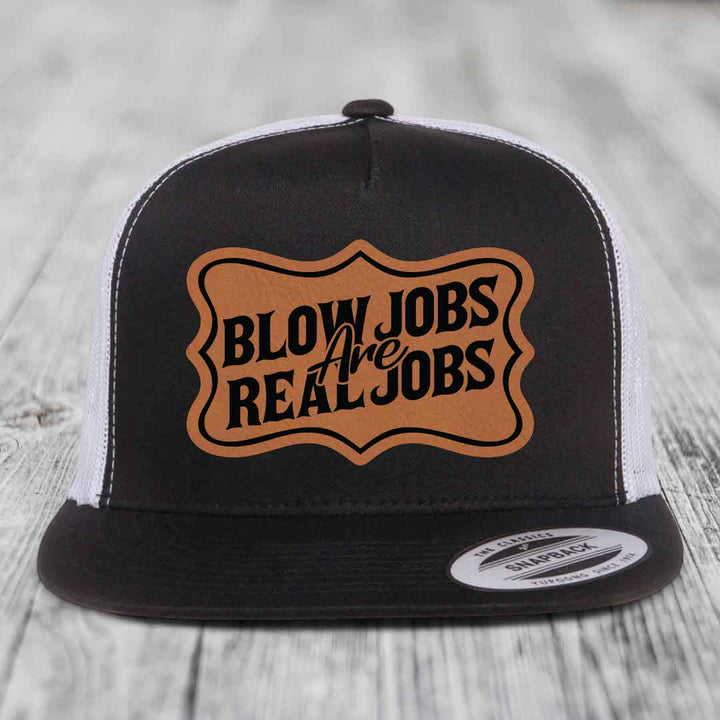 Black and white trucker hat with brown leather patch reading &