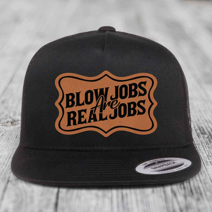 Black snapback hat with brown leatherette patch reading &