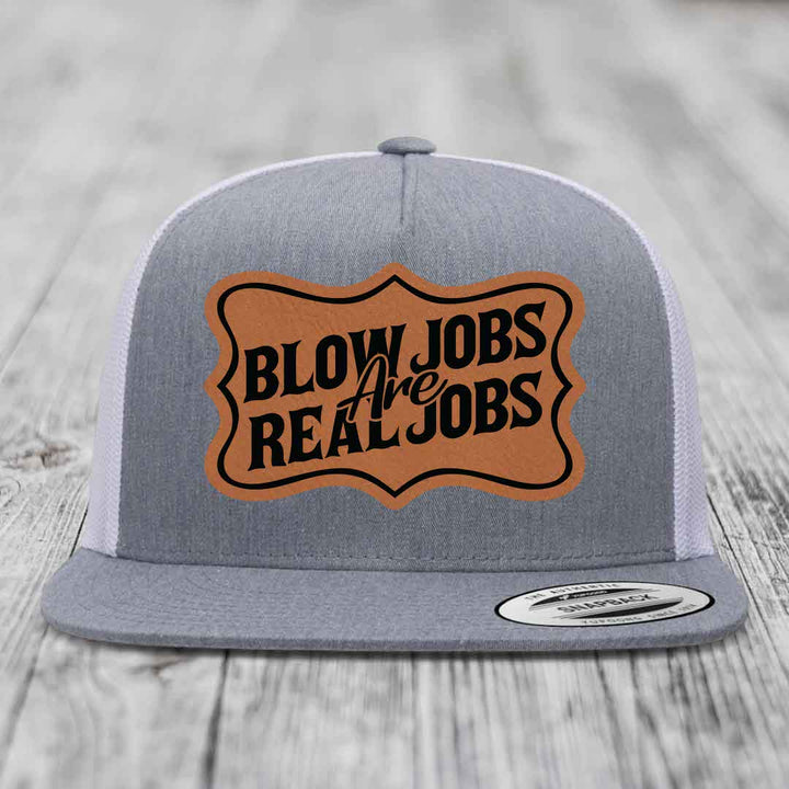 Grey trucker hat with brown leatherette patch reading &