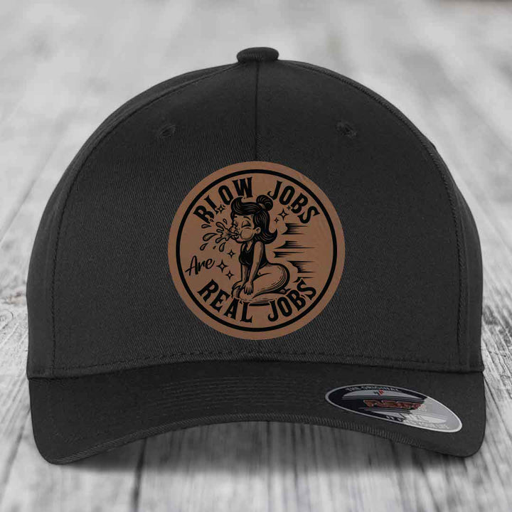 Black baseball cap with circular brown leatherette patch reading &