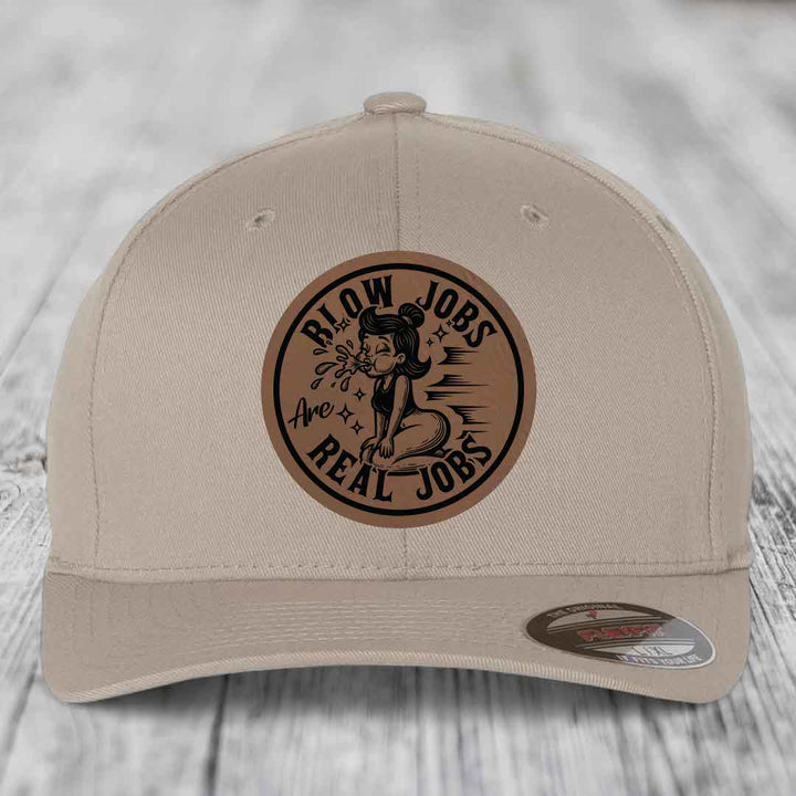 Beige baseball cap with brown circular leather patch reading &