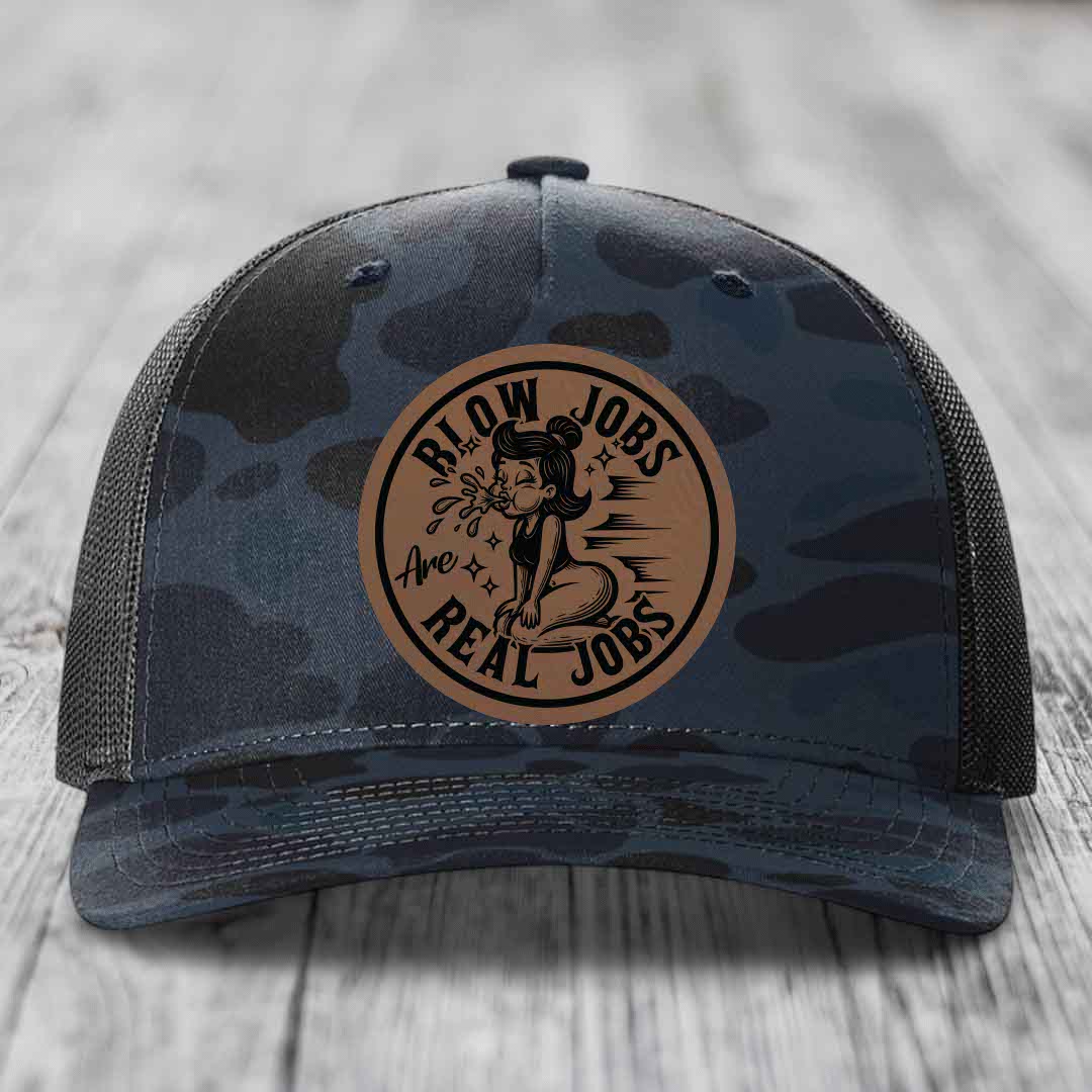 Camouflage trucker hat with brown circular leather patch reading &