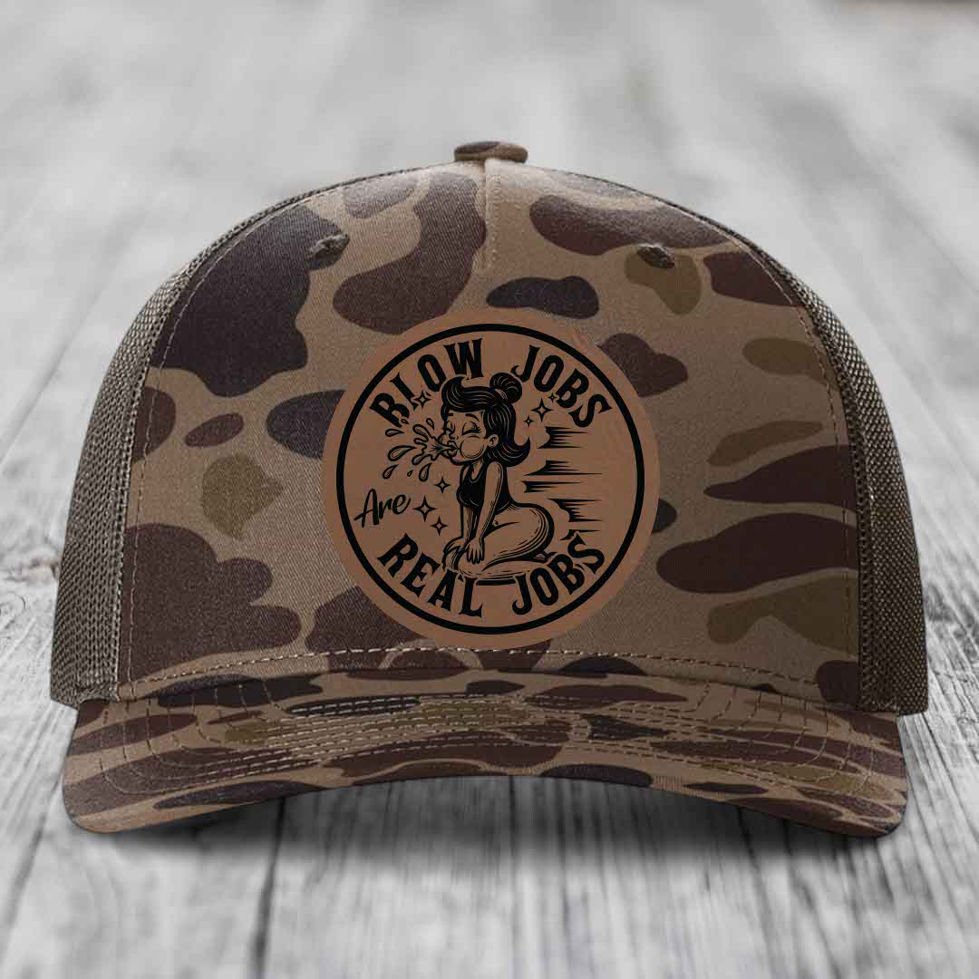 Camouflage trucker hat with a circular leatherette patch reading &